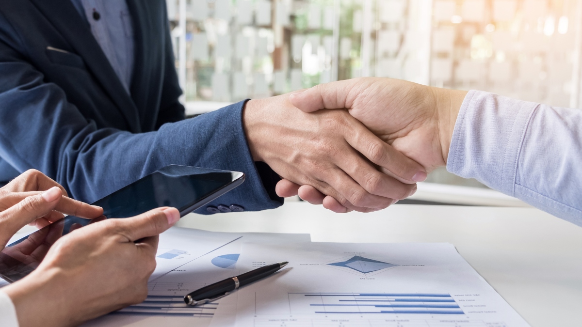 Business handshake of two men demonstrating their agreement to sign agreement or contract between their firms, companies, enterprises